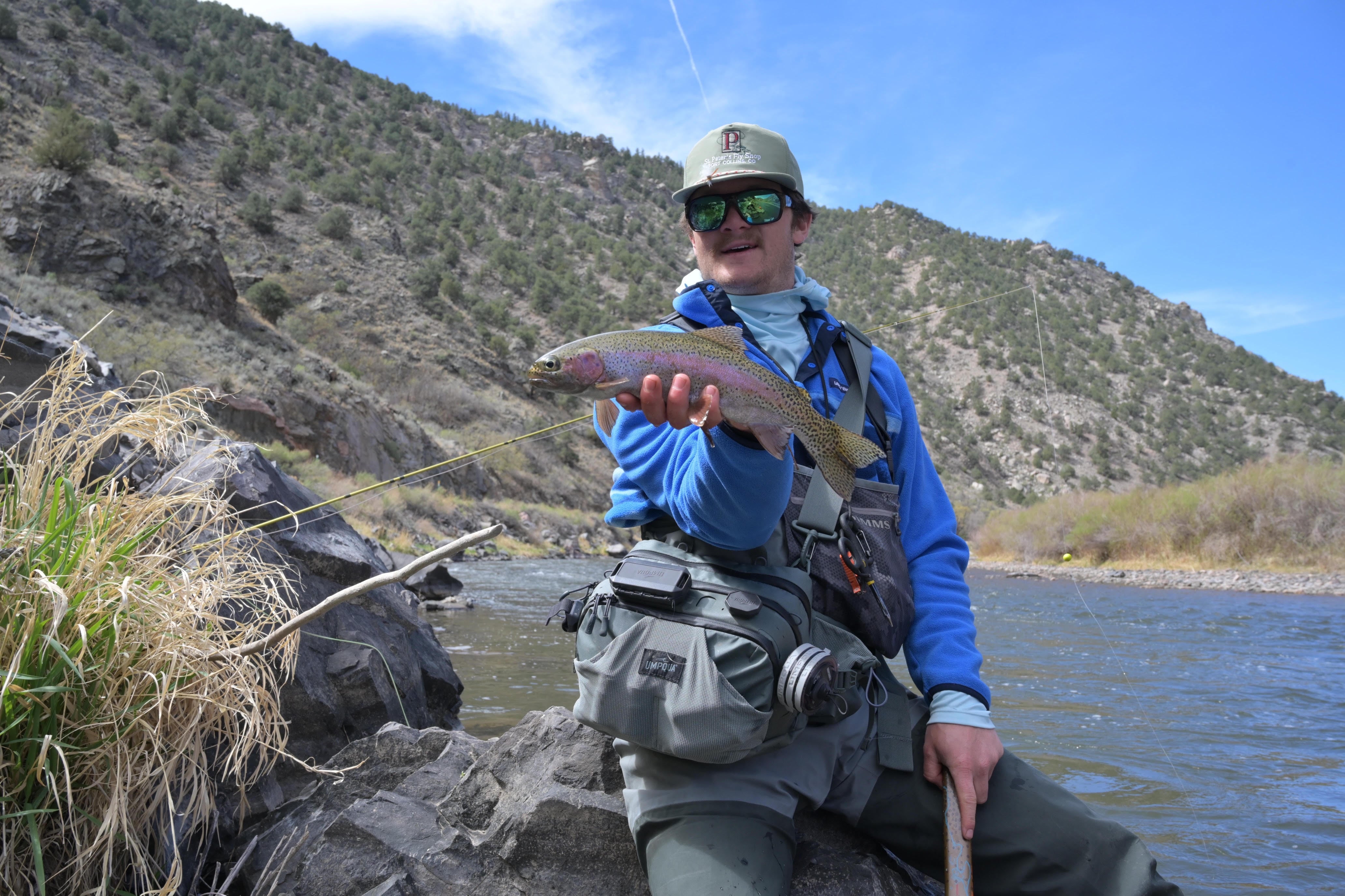 man with fish against mountains