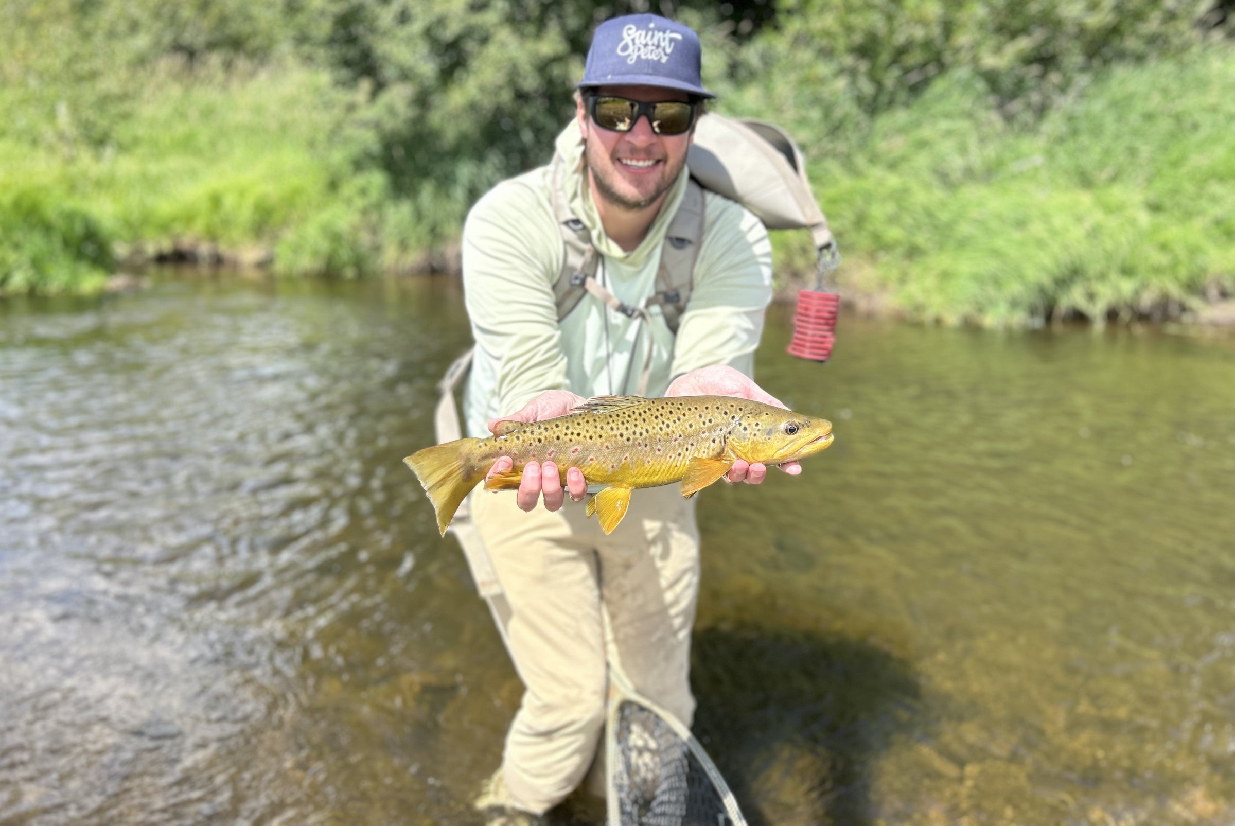 angler in water holding fish